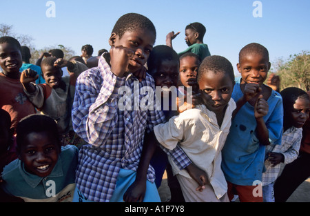 Ragazzi il tifo durante la visione di un villaggio locale partita di calcio, Malawi Foto Stock