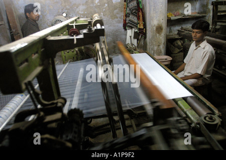 Tessitori di tappeti di armatura in una fabbrica di tappeti nella città di Varanasi in India del nord Foto Stock