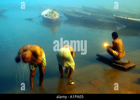 Gli uomini prendere un bagno di religiosi per pulire le anime dai peccati passati nel sacro Gange nella città di Varanasi in India del nord Foto Stock