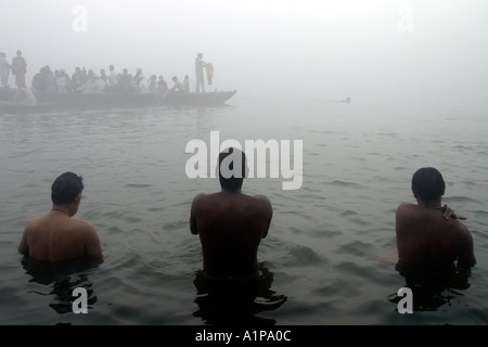 Gli uomini prendere un bagno di religiosi per pulire le loro anime dai peccati passati nel sacro Gange nella città di Varanasi in India del nord Foto Stock