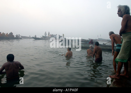 Gli uomini prendere un bagno di religiosi per pulire le loro anime dai peccati passati nel sacro Gange nella città di Varanasi in India del nord Foto Stock