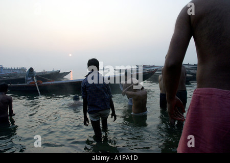 Gli uomini prendere un bagno di religiosi per pulire le loro anime dai peccati passati nel sacro Gange nella città di Varanasi in India del nord Foto Stock