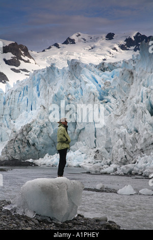 Un escursionista sorge su una messa a terra ice berg e ammira Harriman Glacier Foto Stock