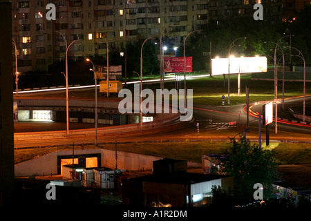 Paesaggio notturno di Kiev con strade illuminate, edifici di appartamenti e sentieri leggeri da veicoli in movimento. Foto Stock