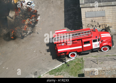 Vigili del fuoco che spengono un incendio a Kiev con un camion antincendio in loco, fumo e fiamme visibili. Foto Stock