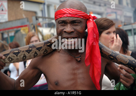 L'uomo con il suo python nel carnevale di Notting Hill.Afro Foto Stock