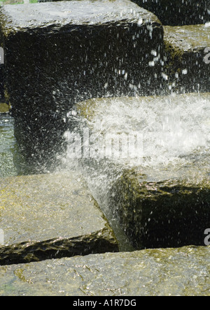 Spruzzi di acqua sul blocco di pietra Foto Stock