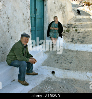 Pomeriggio intimo Chat: un uomo e una donna seduta su ciascun lato di una chiusura sportello blu nella parte anteriore di un bianco lavato house Foto Stock