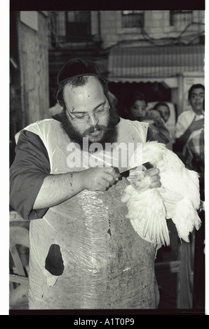 La macellazione di un pollo durante la preghiera Kaparot Mea Shearim a Gerusalemme Foto Stock