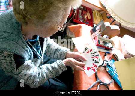 La zia Fran età 92 giocando con grandi carte di stampa affetti da degenerazione maculare. Edina Minnesota USA Foto Stock