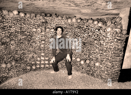 Parigi Francia, giovane uomo visitando il cimitero catacombe sotterranee scheletri memoriale della morte Foto Stock