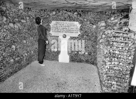 Parigi Francia, maschio turisti in visita nel cimitero sotterraneo "Catacombe" (bianco e nero) Foto Stock