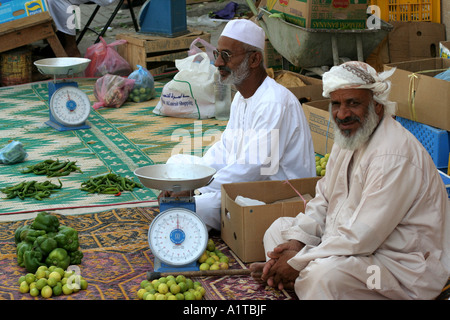 Gli uomini per la vendita di frutta e verdura in un suk in Sinaw, vicino a Nizwa, Oman Foto Stock