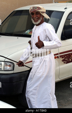 Il vecchio uomo in un suk in Sinaw, vicino a Nizwa, Oman indossando un tradizionale coltello khanjar Foto Stock