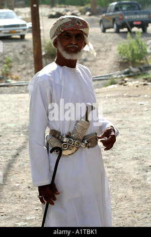 Il vecchio uomo in un suk in Sinaw, vicino a Nizwa, Oman indossando un tradizionale coltello khanjar Foto Stock