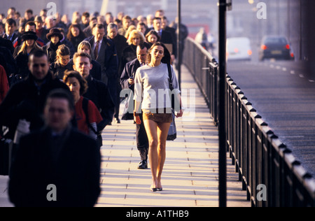 Donna che indossa mini gonna intorno a Londra Rush Hour del ponte di Londra 2001 Foto Stock