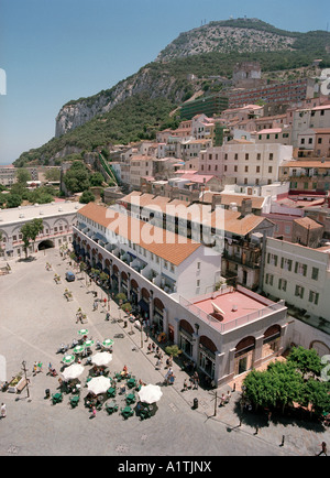 I turisti godendo il sole a Casemates Square, Gibilterra, con la roccia dietro Foto Stock