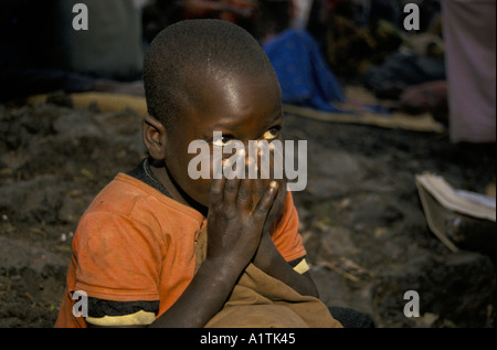 GOMA DELLO ZAIRE profughi ruandesi in KIBUMBA REFUGEE CAMP LUGLIO 1994,bambino seduto con le mani davanti al suo volto. Foto Stock