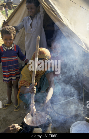 L' Eritrea . Restituite i rifugiati provenienti dal Sudan che vivono in tende 1993 Madre per la cottura sul fuoco aperto Foto Stock