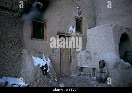 AFGHANISTAN BAMIYAN 1998 .uomo accovacciato al di fuori della sua casa in una grotta abitazione vicino al Grande Buddha 1998 Foto Stock