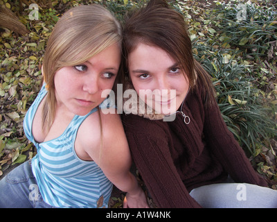 Due ragazze adolescenti seduto per terra di schiena Foto Stock