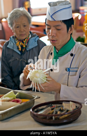 Cina fiume Yangtze Chef dimostrando come di scolpire il cavolo Foto Stock