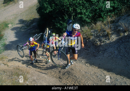 Mountain Bike ciclisti,portando le loro biciclette in cima ad una collina molto ripida in Staffordshire campagna. Foto Stock