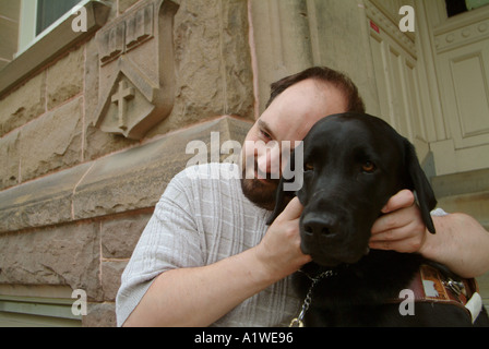 Yvan Tessier e il suo occhio vede cane sui gradini di Univeristy di New Brunswick edificio Foto Stock