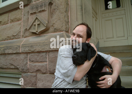 Yvan Tessier e il suo occhio vede cane sui gradini di Univeristy di New Brunswick edificio Foto Stock