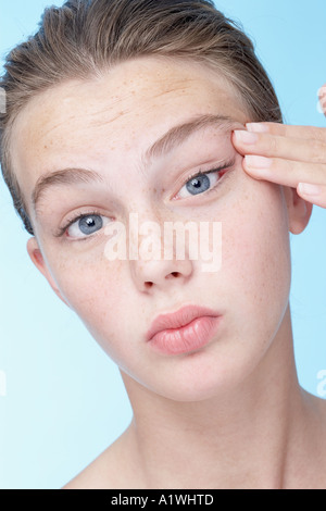 Ritratto di una giovane donna tirando la sua pelle Foto Stock