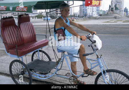 Uomo alla guida di un triciclo vuota, cercando per i turisti a dargli il lavoro. LA HAVANA CUBA 2001 Foto Stock