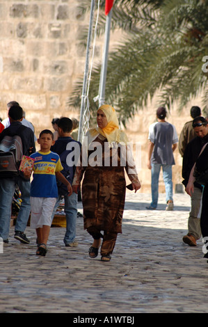 Donna tunisino con il figlio a piedi attraverso il bazaar sulla medina della città di Sousse in Tunisia Foto Stock