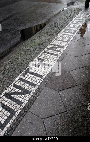 Unità nella libertà di cui nella pavimentazione al Checkpoint Charlie Berlino Germania Foto Stock