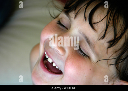 Ragazza giovane di gettare la testa indietro e ridere Foto Stock