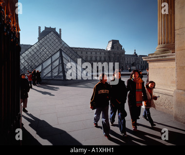 I turisti che visitano il museo del Louvre e la piramide di vetro disegnato da Sino architetto americano Pei. Foto Stock