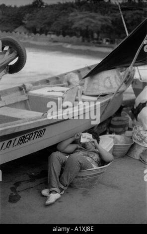 Una donna la lettura di un libro in un mercato la libertad El salvador Foto Stock