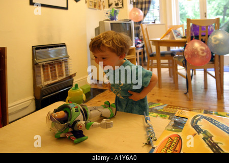 Ragazzo aprendo la sua presenta in occasione del suo terzo compleanno Foto Stock
