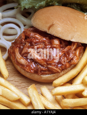 Close up BBQ di maiale barbecue rotolo sandwich di anelli di cipolla friggere french fries chips pranzo snack Foto Stock