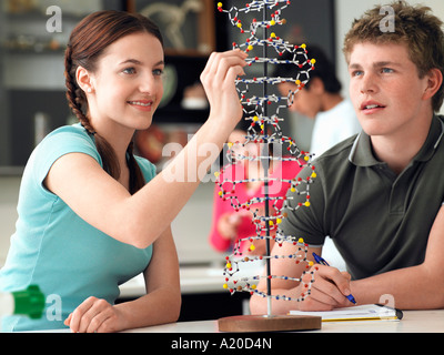 Gli adolescenti lavorando sul modello di DNA nella classe di scienze Foto Stock