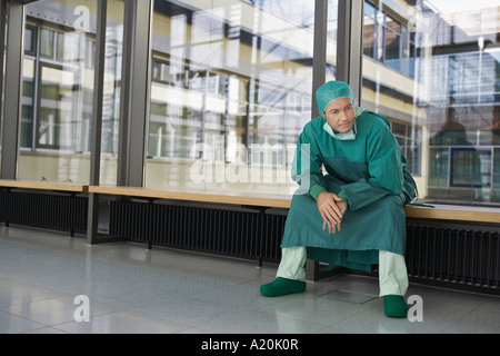 Malinconici medico seduta nel corridoio di ospedale Foto Stock