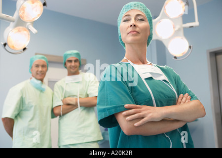 Testa della squadra chirurgica con chirurghi in sala operatoria, ritratto Foto Stock