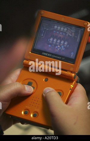 Le mani di un bambino giapponese di riproduzione di Gameboy, Tokyo, Giappone Foto Stock