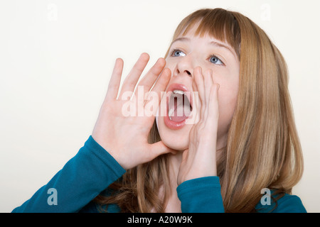 Ragazza adolescente, mani ammanettato attorno alla bocca, gridando, close-up Foto Stock