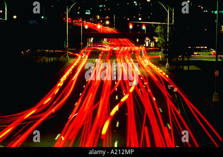 Luci sfocate di traffico che viaggia attraverso un centro di intersezione di notte Foto Stock