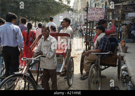 In rickshaw driver sulle strade affollate di Chandni Chowk in Delhi India Foto Stock