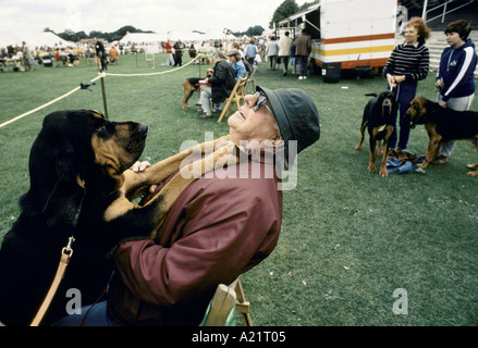 Cane salto mettendo S zampe sul petto dei proprietari a concorrenza BLOODHOUND ASCOT 1985 Foto Stock