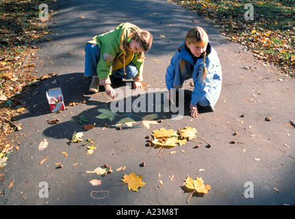 Due ragazze disegno sul marciapiede Foto Stock