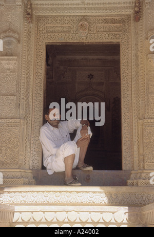 Un uomo di Rajasthani seduto alla porta dell'Patuwa Ki Haveli in Jaisalmer. Rajasthan, India. Foto Stock