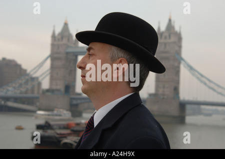 Tradizionale città britannica gent in Bowler cappello e business suit da Tower Bridge, London, Regno Unito Foto Stock