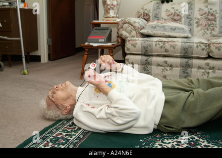 Femmina Senior utilizza un medical alert sistema di allarme per la chiamata di emergenza per aiutare dopo la caduta Foto Stock